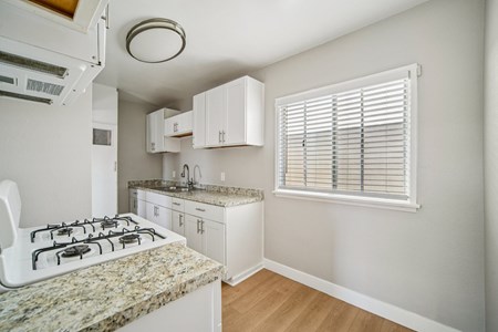 A kitchen with a granite countertop and white cabinets.